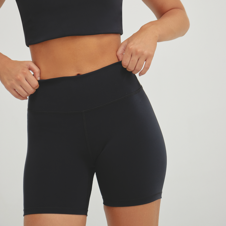Woman wearing black high-compression biker shorts designed for sculpting support, secure fit, and performance training.